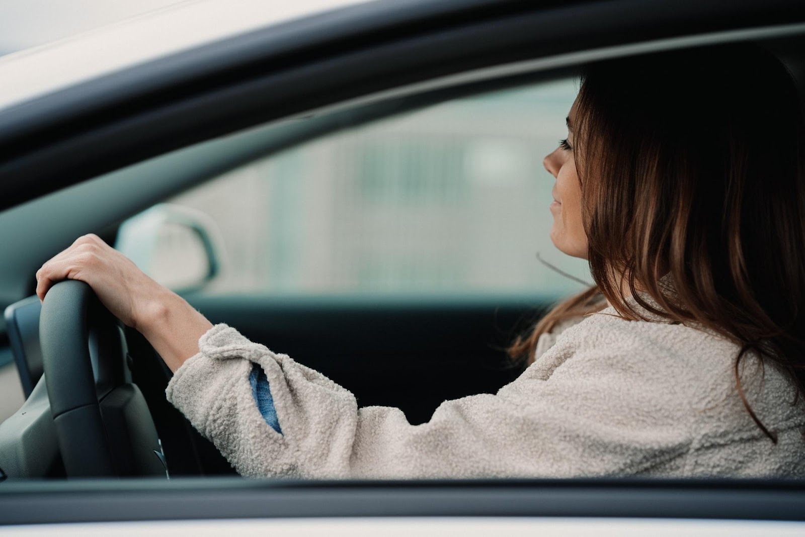 A picture of a woman driving down the road with peace of mind knowing her car is protected by CarGuard Administration
