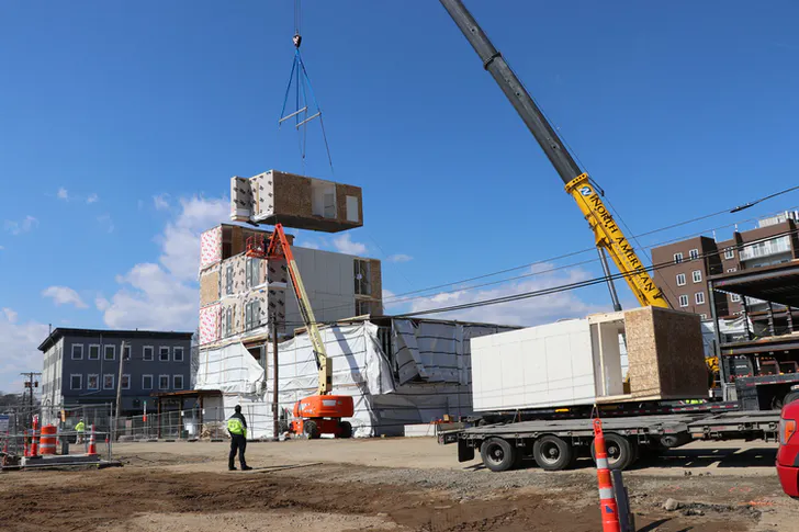 Crane lifting modular constructions at a sea port