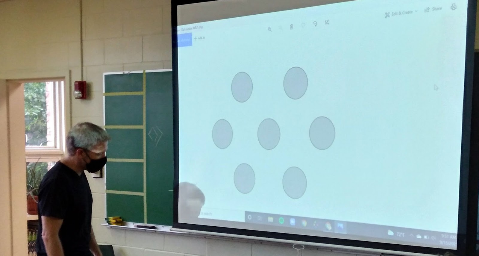 Teacher shows math exercise on a projector screen