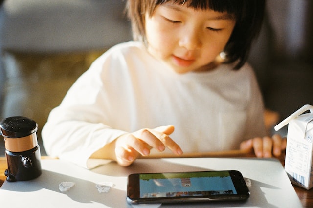 Young toddler-aged girl playing on tablet.
