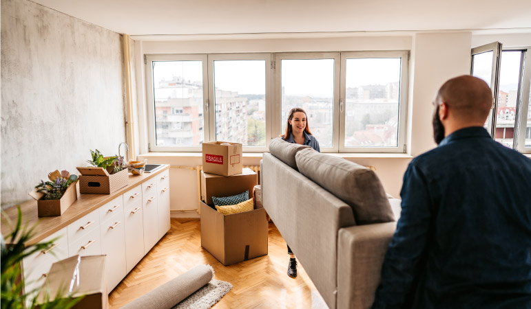 A couple moving their couch into their condo