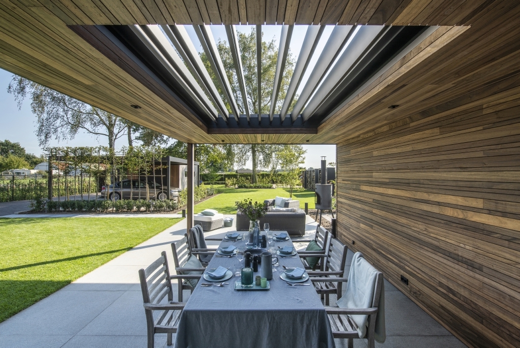 grey louvred roof system integrated in to a wooden style ceiling of a home with a dining table and chairs underneath