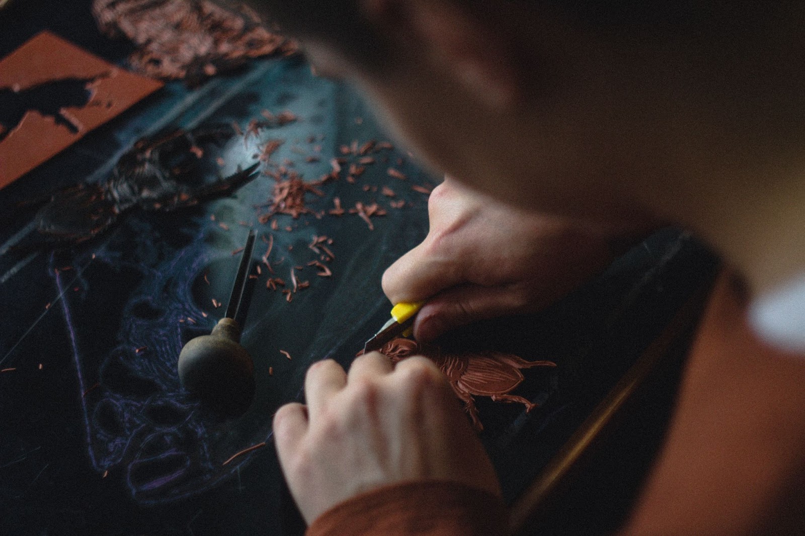 person carving leather goods