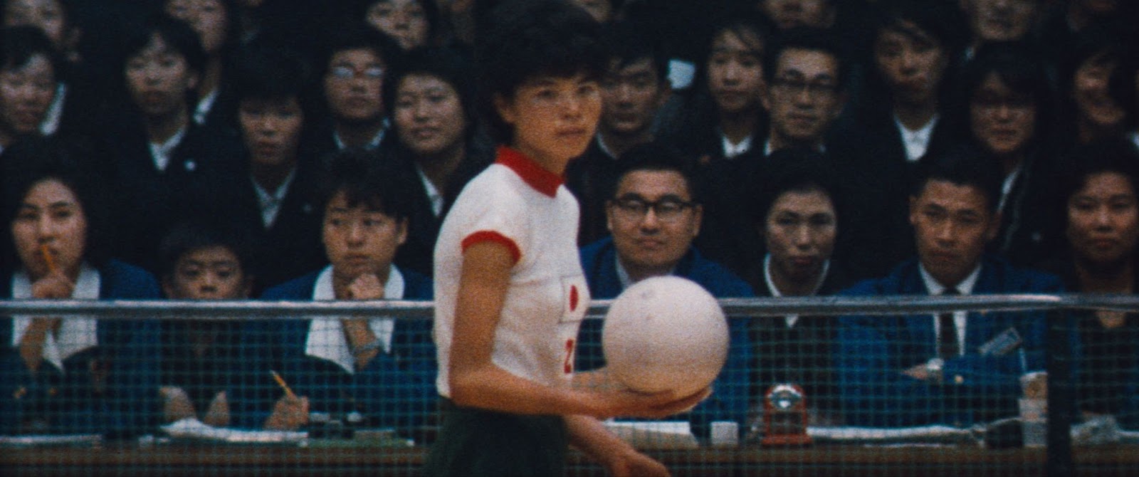 A screen still from The Witches of the Orient, featuring a scene of archival footage from one of the games played by the volleyball team.