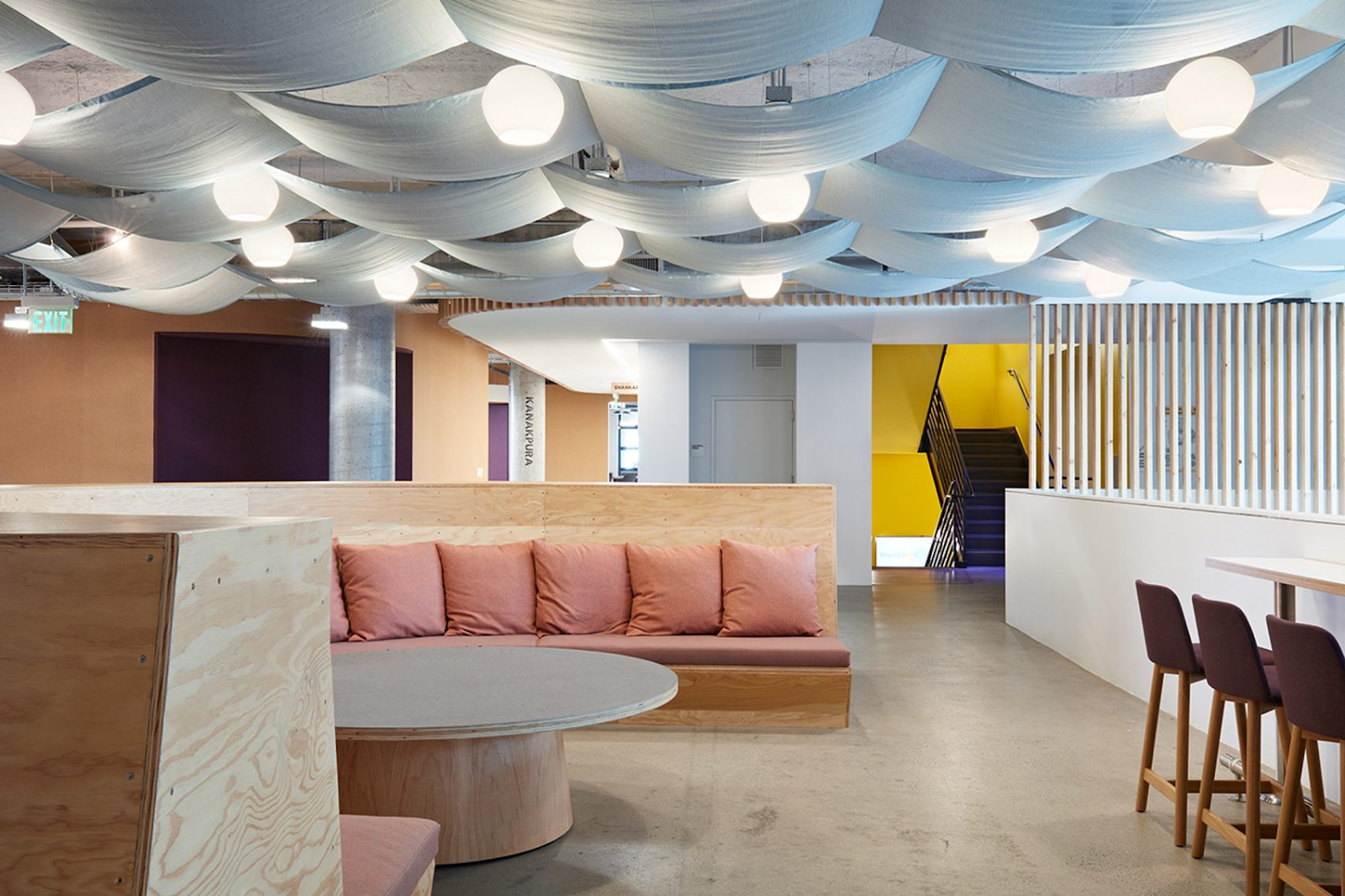 Comfortable lounge area with light pastel colors and wavy ceiling tapestries in Airbnb's HQ in San Francisco