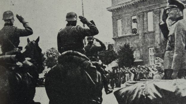 Photograph of Arthur Greiser (1897-1946), a Nazi German politician, SS-Obergruppenführer and Reichsstatthalter, saluting his troops after the Battle of Lódz, Poland. Dated 1939