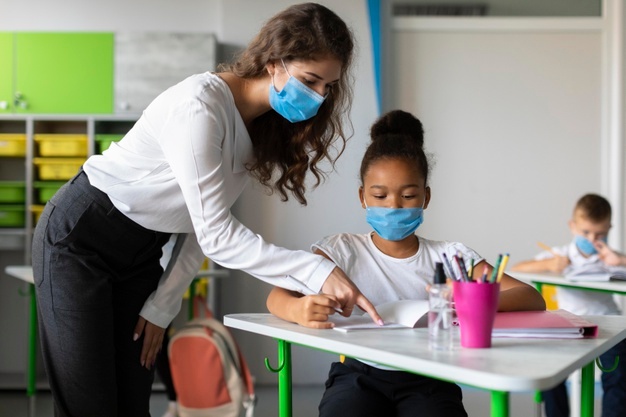 Teacher showing a student how to solve a problem Free Photo