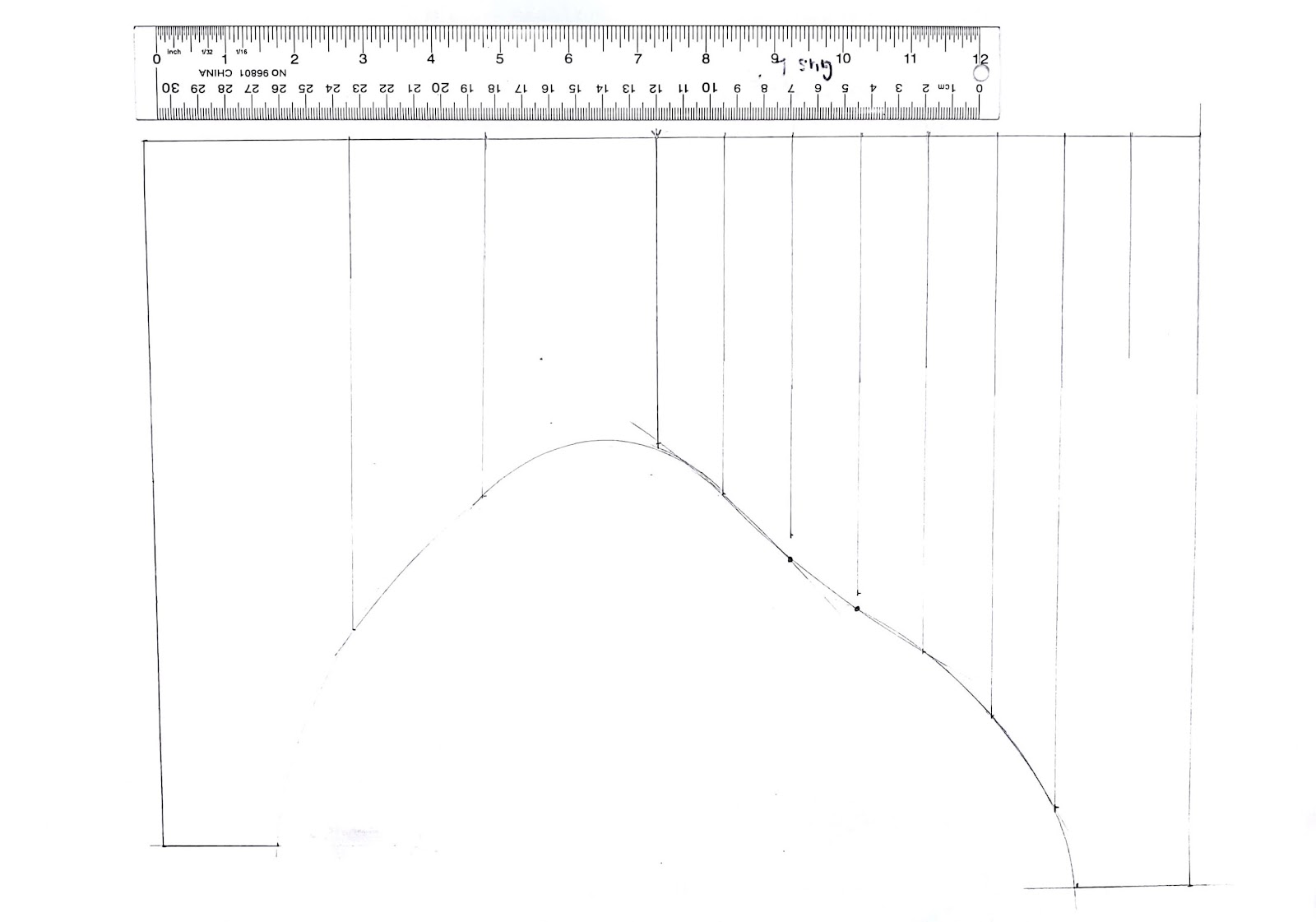 A scan of a hand drafted pattern with a ruler beside it for scale.
