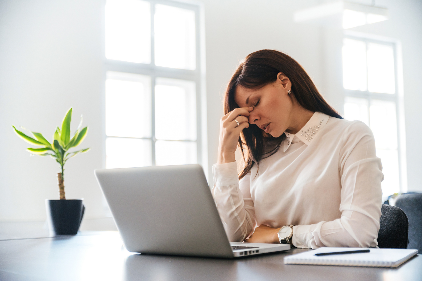 A woman stressed while working on her laptop 