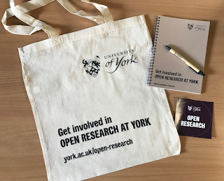 York Open Research merchandise, including a tote bag, pen, notebook and sticker