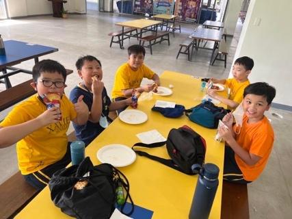 A group of boys eating at a table

Description automatically generated with medium confidence