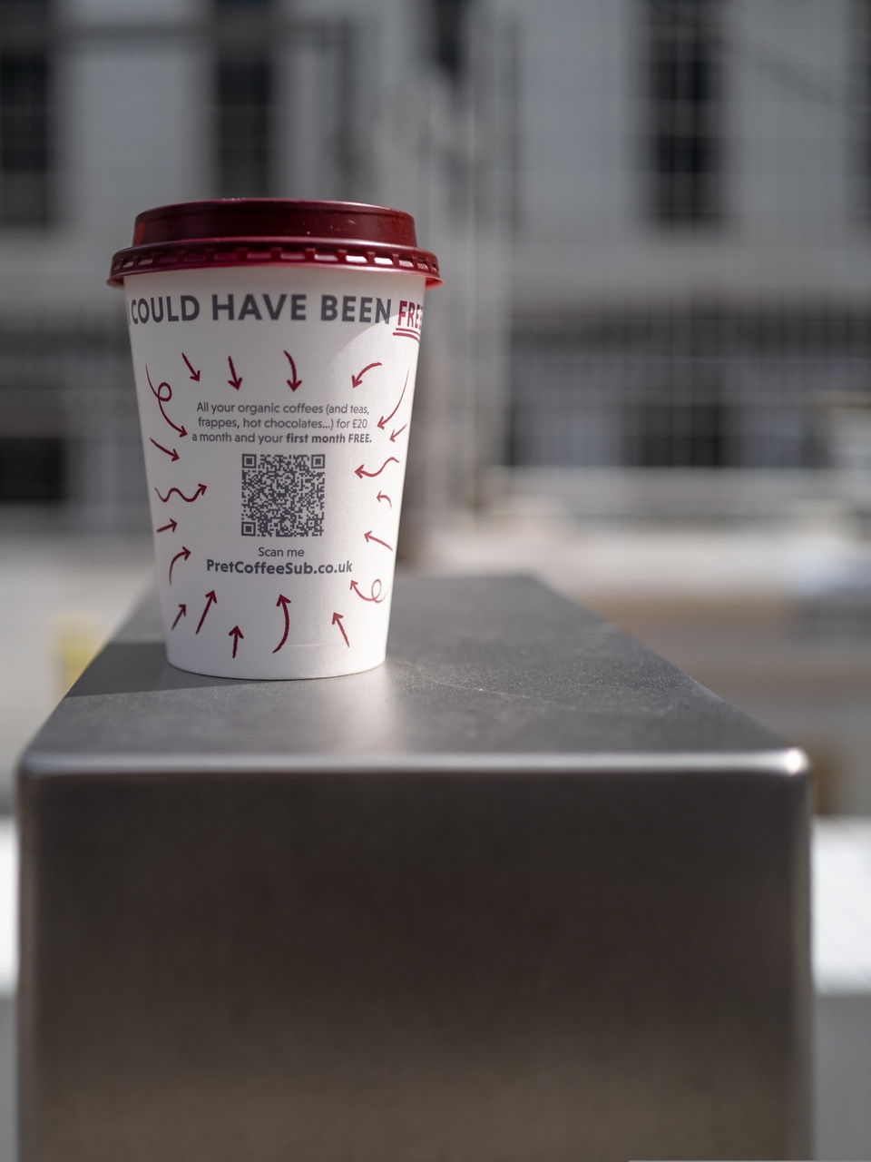 a paper coffee cup with a QR code on it