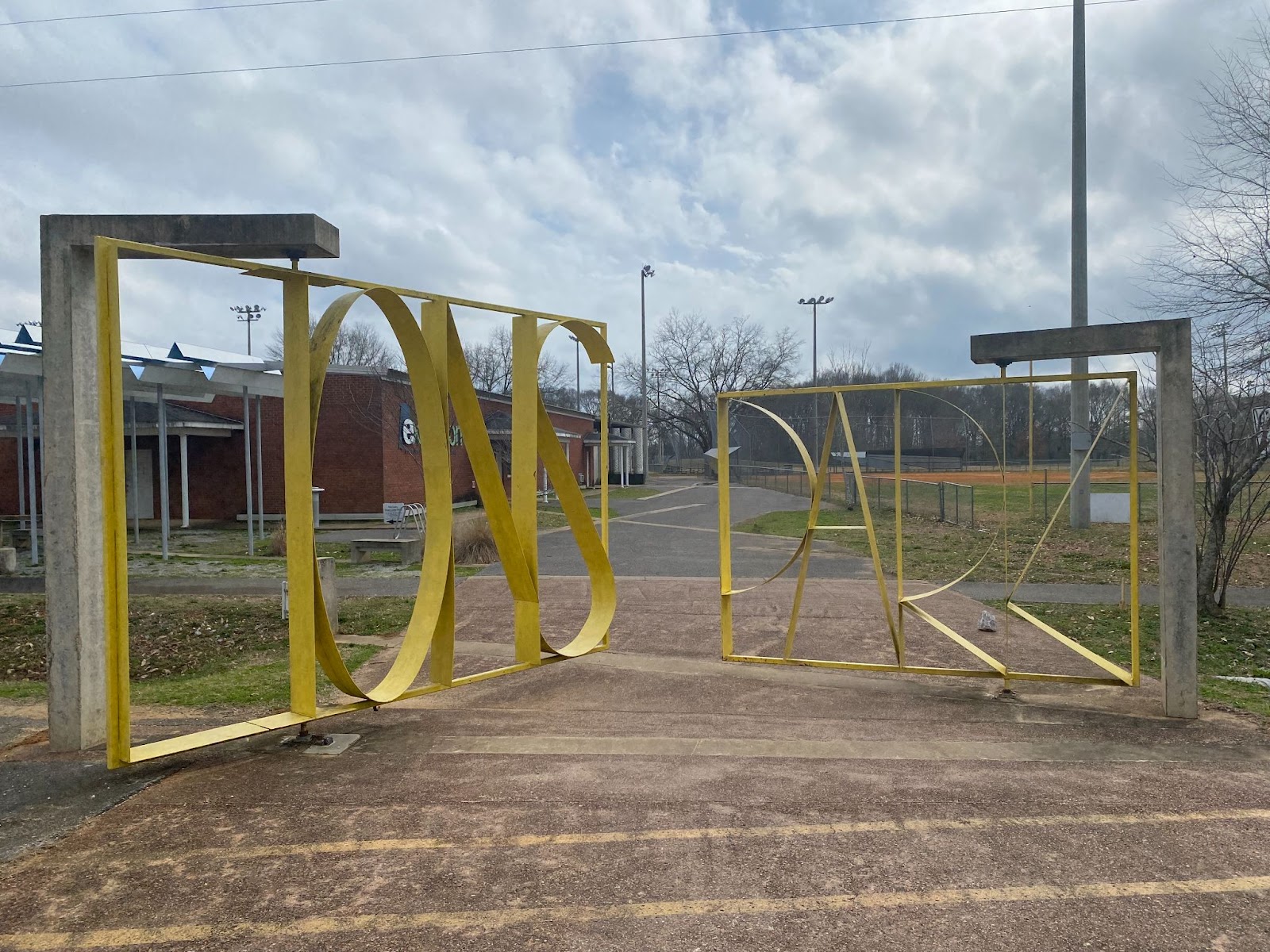 Large metal swinging gates that spell out the words "Lions Park."