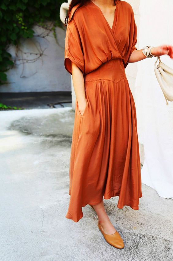Una mujer muestra un vestido largo hasta el tobillo en color naranja, una de las tendencias primavera verano 2020