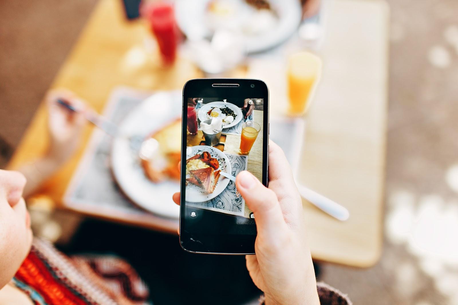 taking a photo of restaurant food