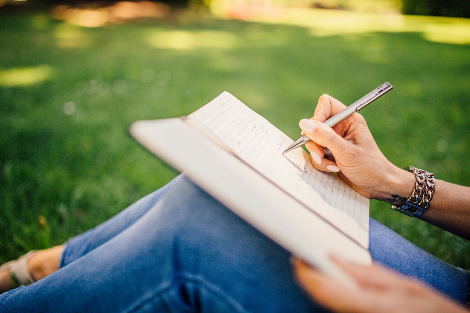 person journaling on the grass
