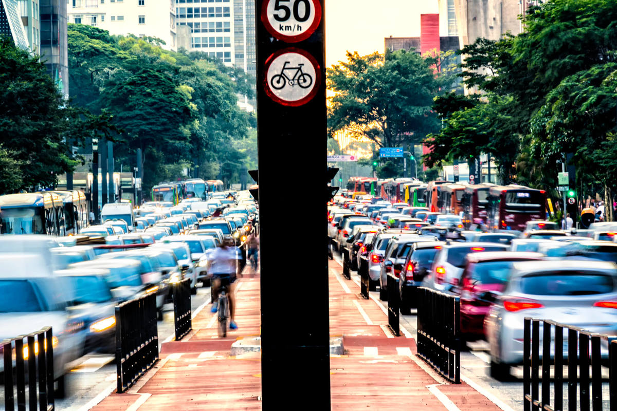 Carros passando na avenida paulista e ciclistas na ciclofaixa da mais conhecida avenida da cidade São Paulo.
