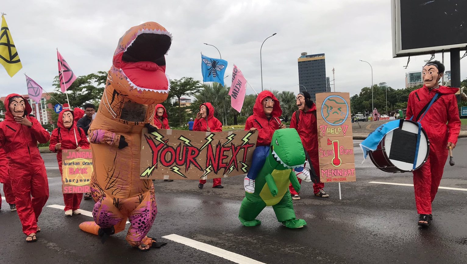 Rebels in Dali masks and dinosaur outfits march down a highway.