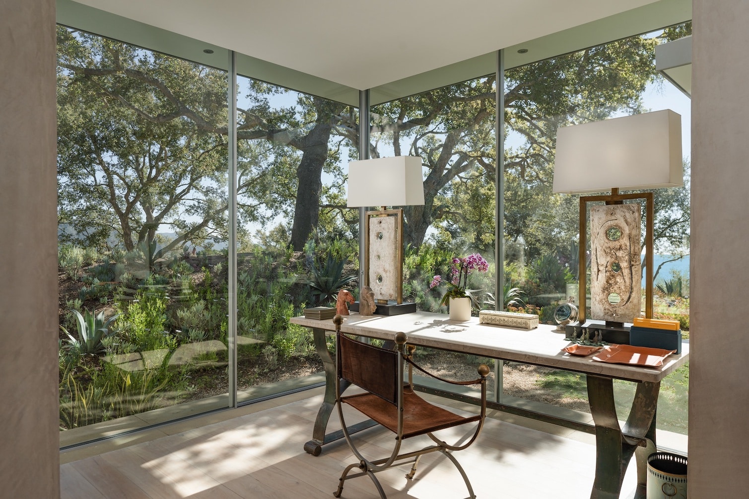 A home office with a view of trees and lush landscape
