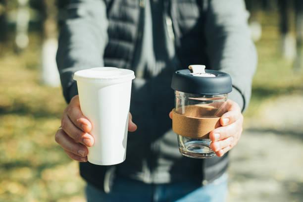 Men holding takeaway coffee cup and disposable paper cup with plastic lid. Conscious choice Men holding takeaway coffee cup and disposable paper cup with plastic lid. Conscious choice. Zero waste concept insulated tumbler stock pictures, royalty-free photos & images