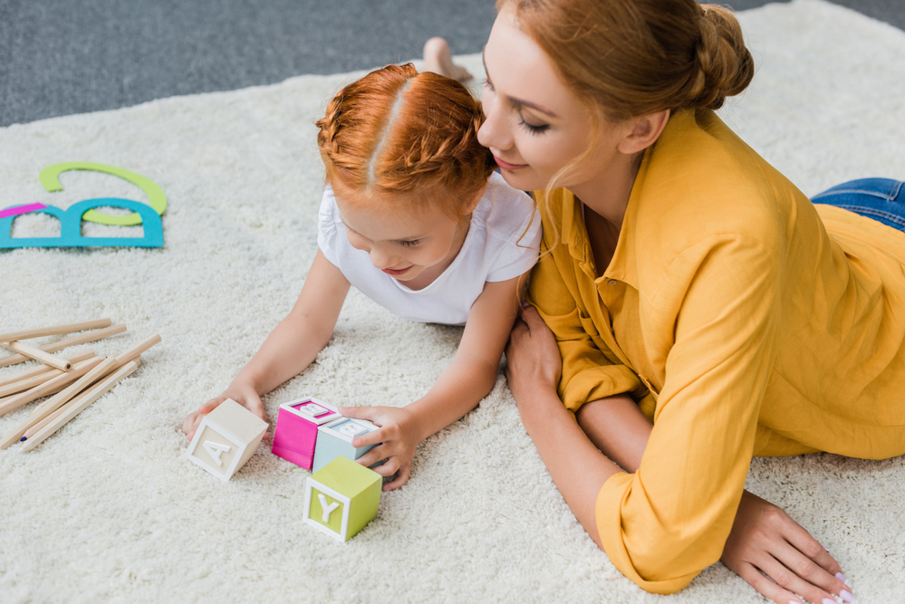 Girl learning phonograms from her mom with blocks