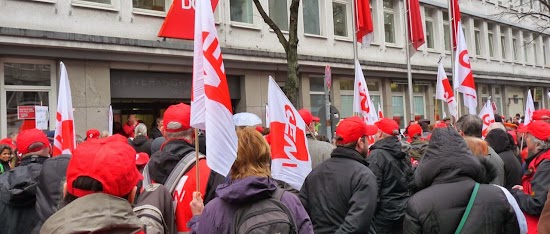 Rotbemützte Gewerkschafter mit GEW-Fahnen.