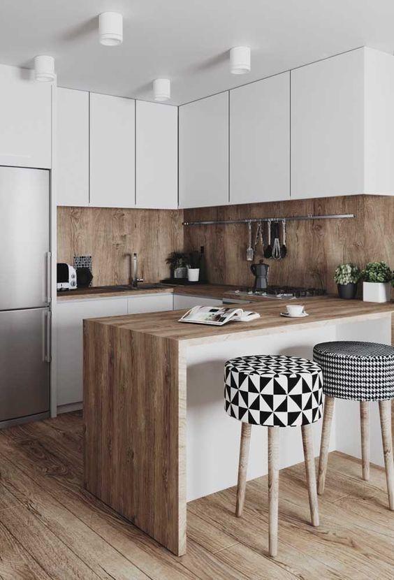 Cozinha com armários brancos, piso, bancada e revestimento da parede amadeirados e banco com estrutura de madeira e estofado preto e branco