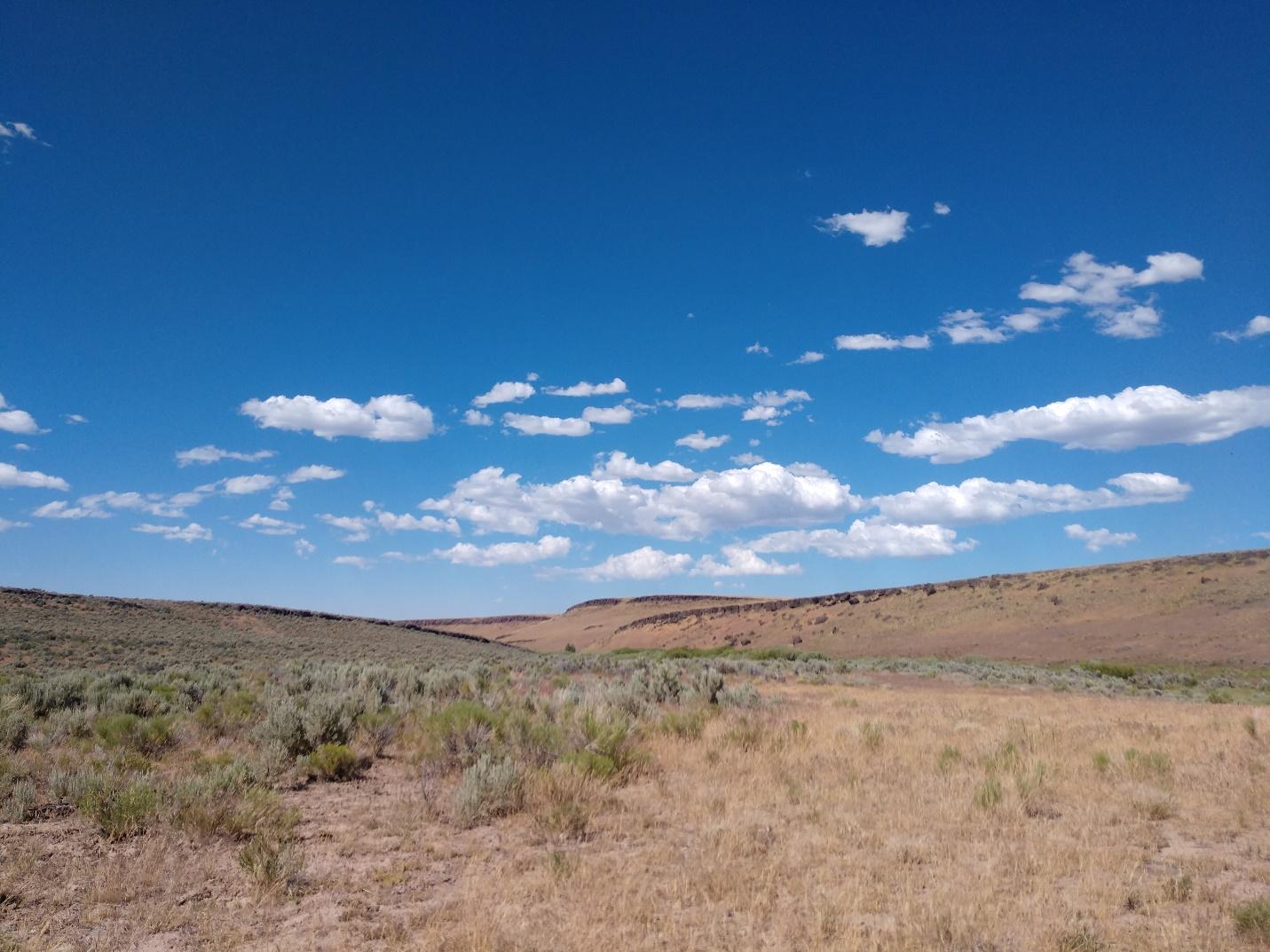 A landscape with blue sky and clouds

Description automatically generated with low confidence