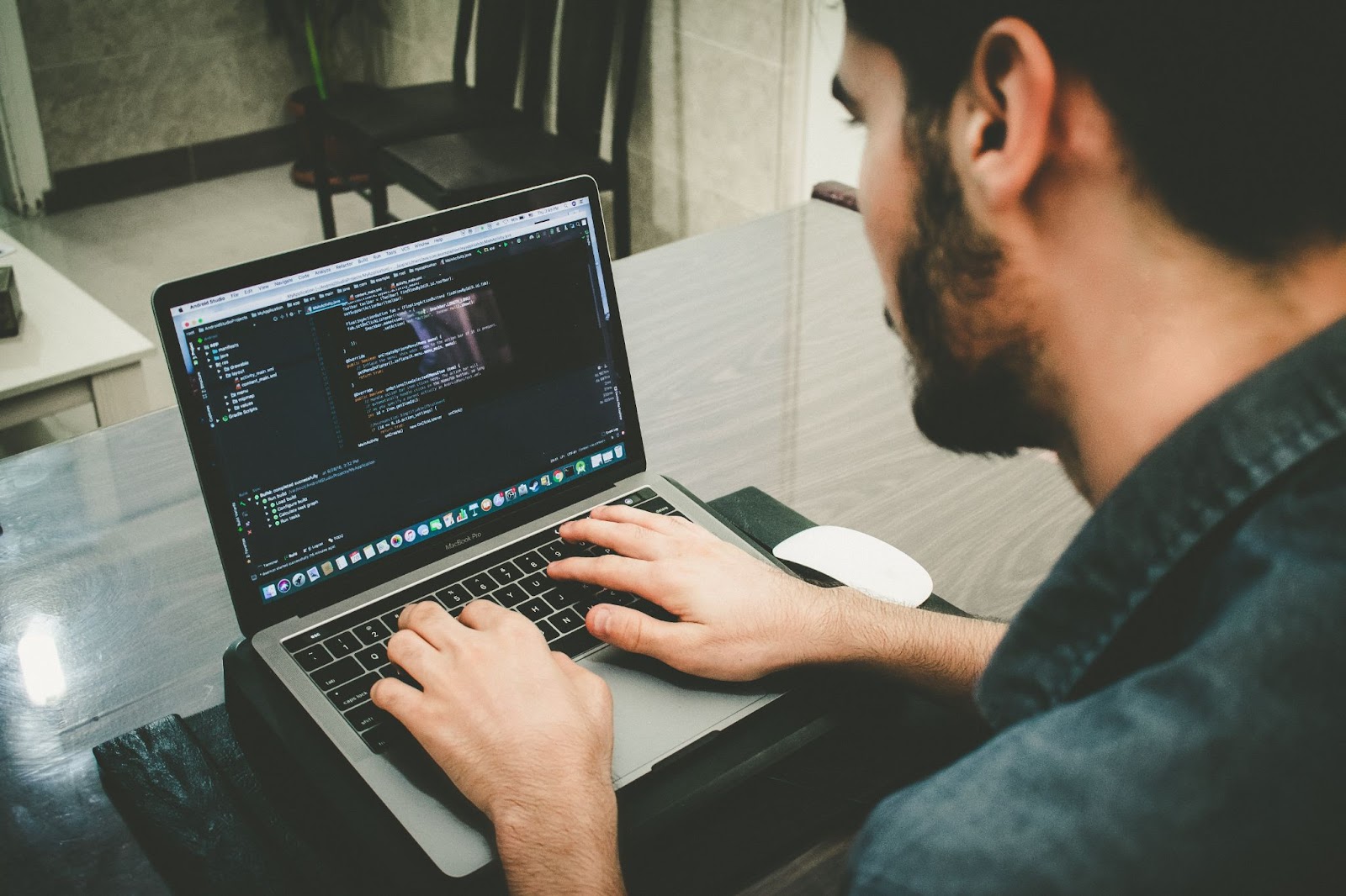 A man typing code on his laptop