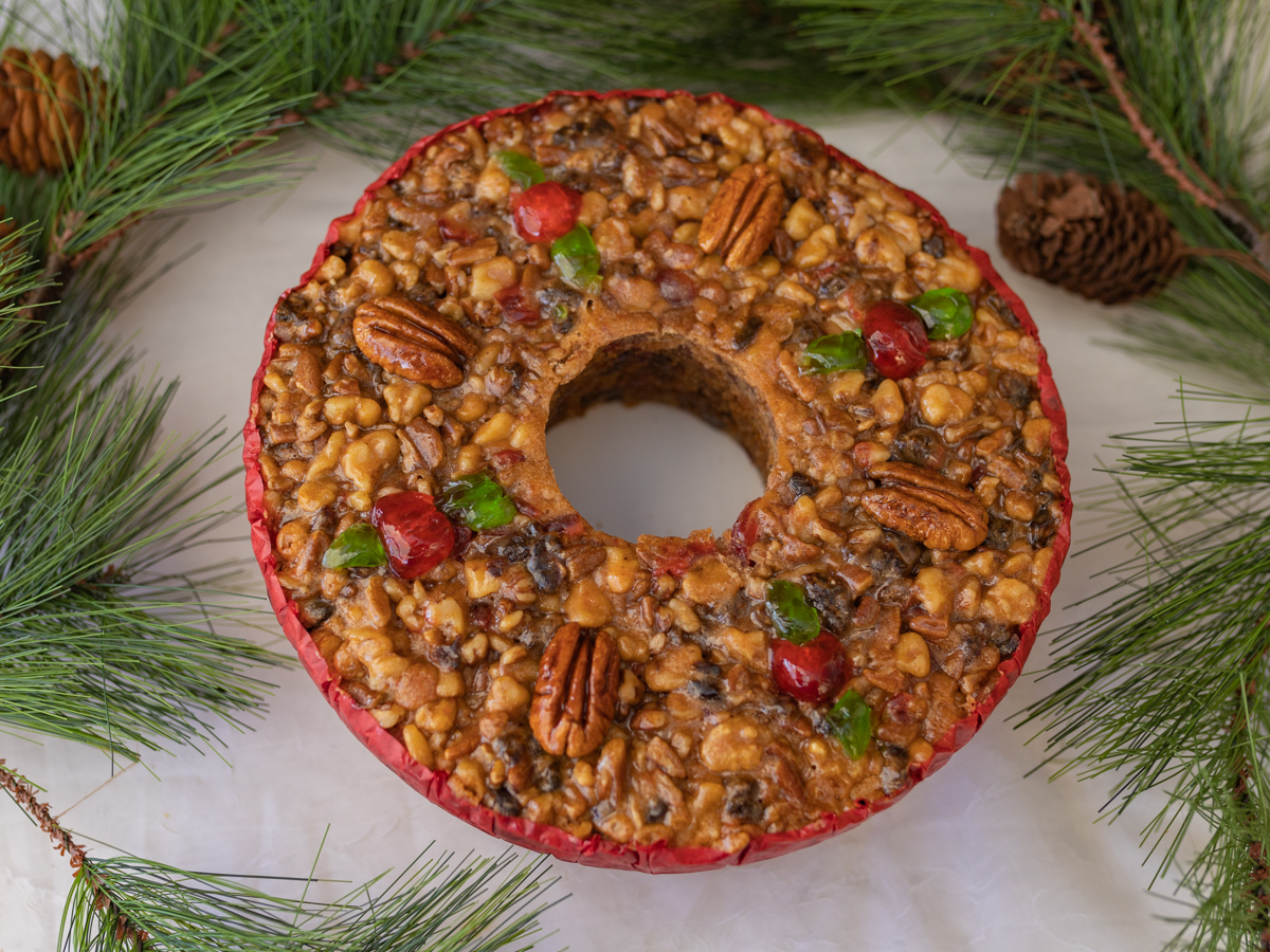 ring-shaped fruitcake surrounded by pine leaves