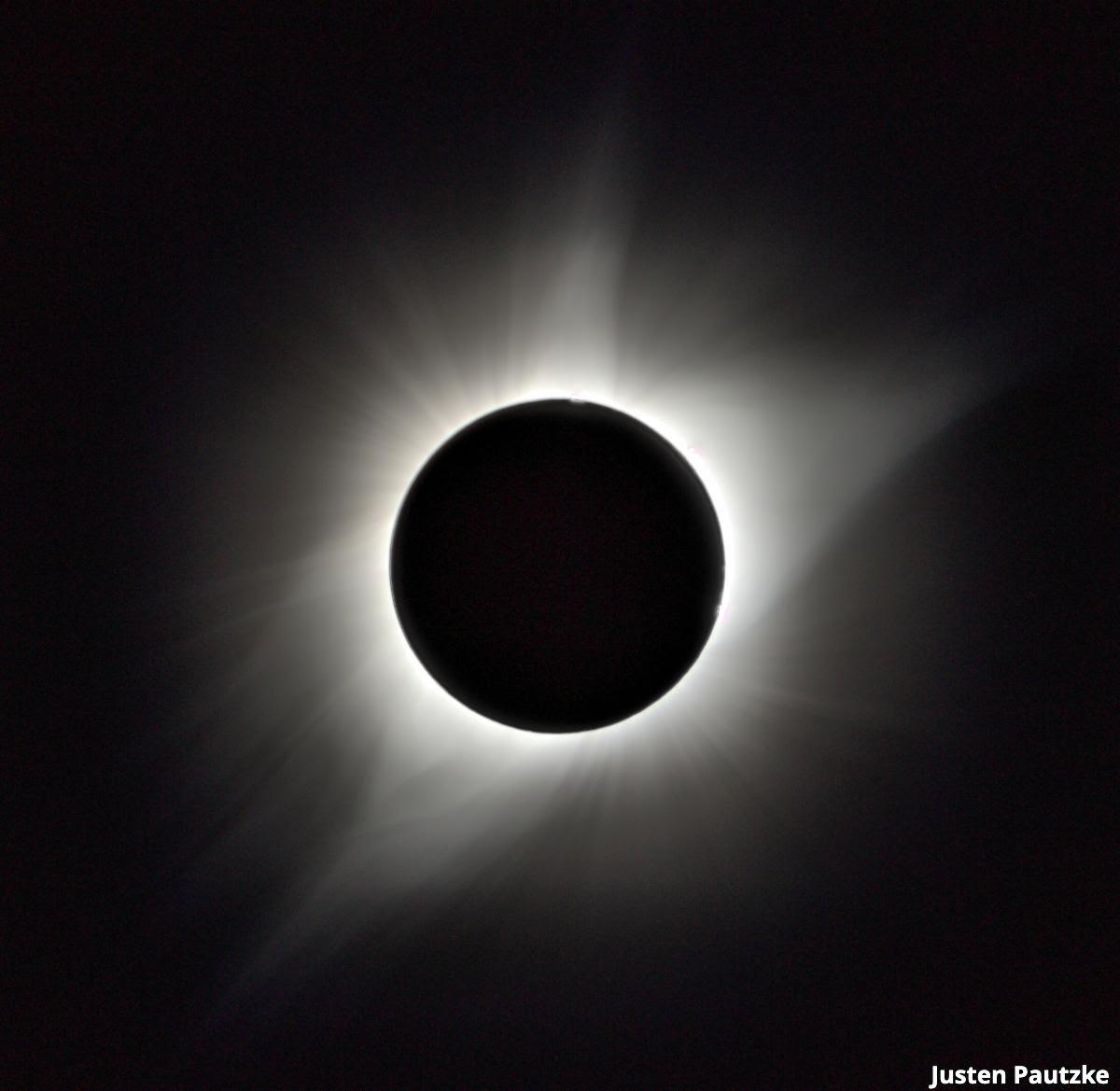 An image of the total solar eclipse showing the glowing coronal layer around the black disc of the moon, by Justen Pautzke
