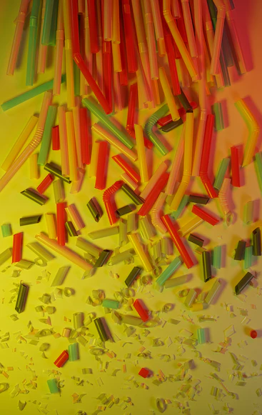 A pile of multi-coloured plastic straws and their broken pieces