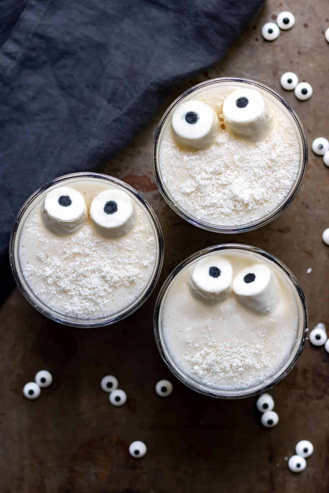 Ghost smoothie recipe - white smoothie decorated with "eyeballs" to look like a ghost - in a white glass.