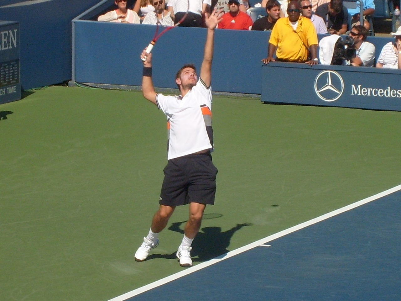 A tennis player delivering the service shot.