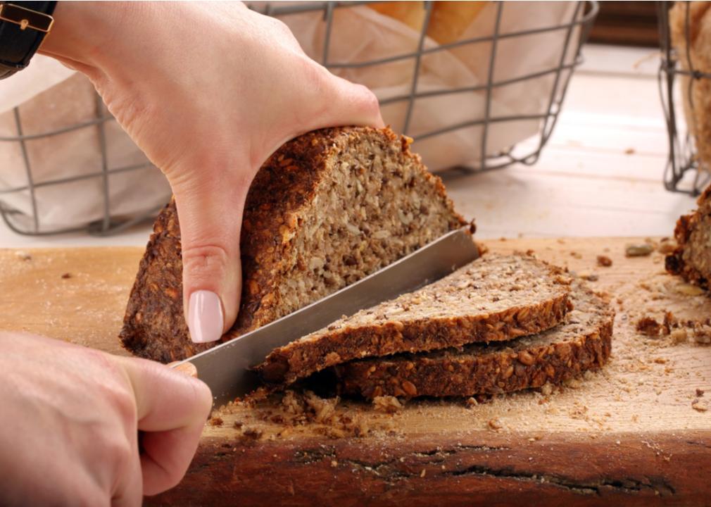 Slicing a whole grain loaf of bread.