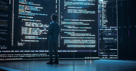 a woman looking at codes on a big screen