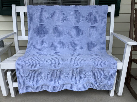 light blue loom knit blanket on porch bench