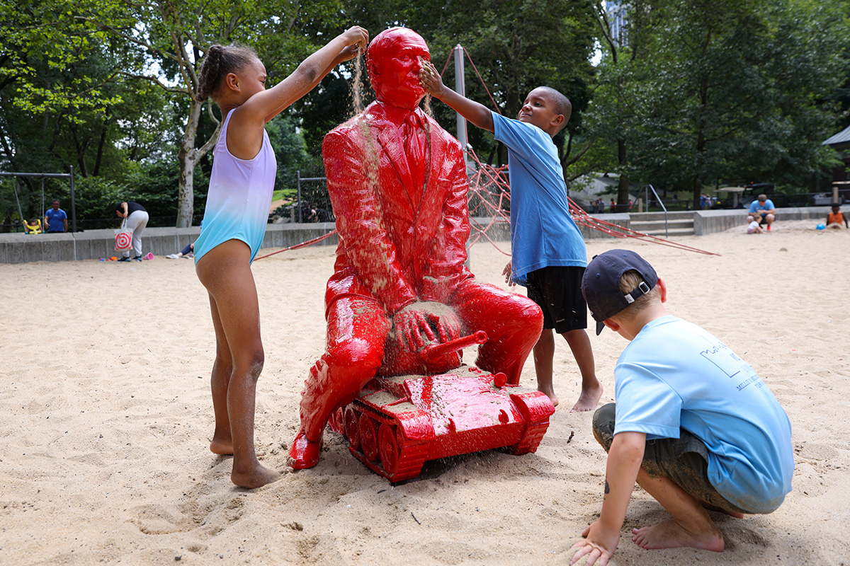 Кажется, ребенок пытается накормить скульптуру Владимира Путина песком, Нью-Йорк, 2 августа 2022 года. Фото: Reuters
