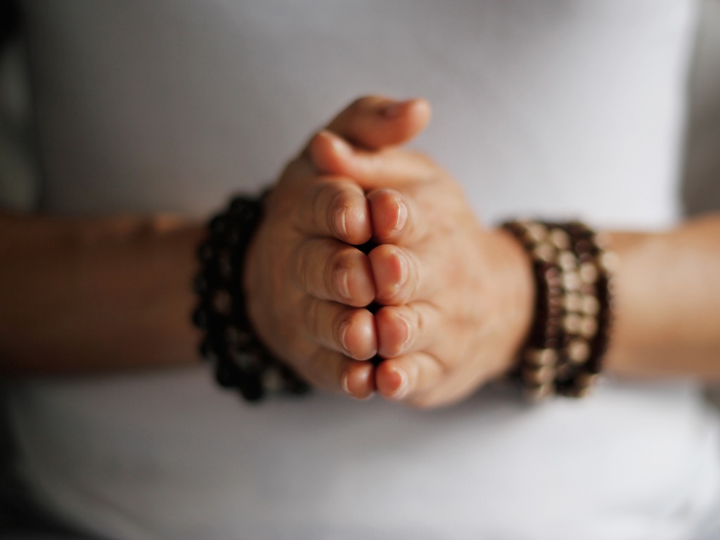 Hands together with bracelets on wrist as a reminder for gratitude