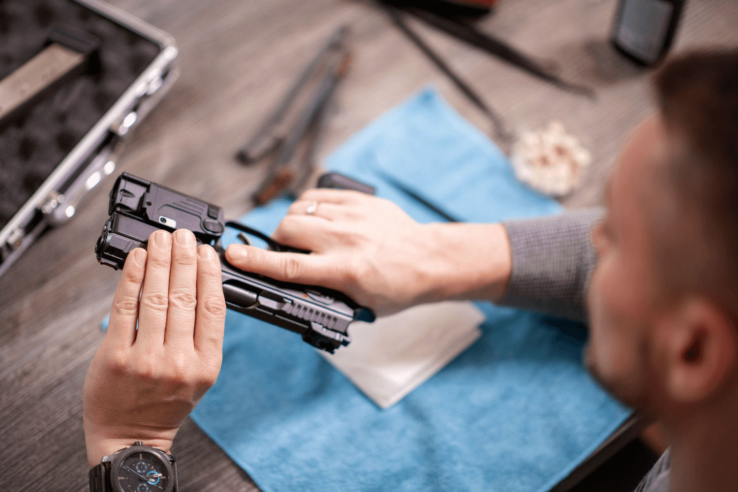 Gunsmith disassembling a handgun with all of his gun cleaning supplies in the background