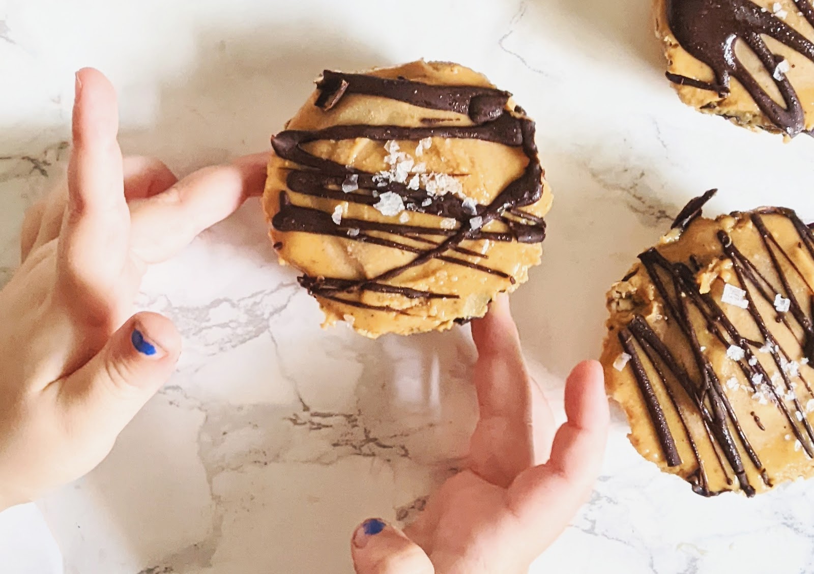 top down view of a child's hand reaching for peanut butter oat cup