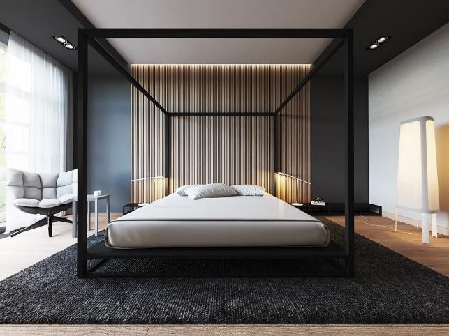 Quarto com cama de casal em estrutura de ferro preto, paredes pretas, piso de madeira e poltrona cinza.