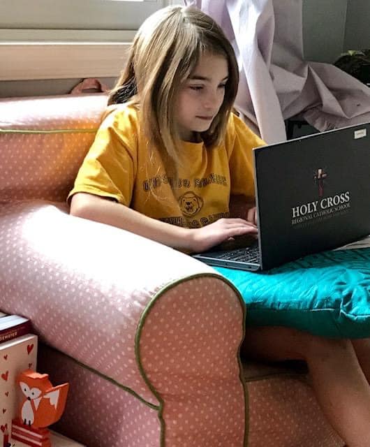 Holy Cross student works online with school-supplied Chromebook.