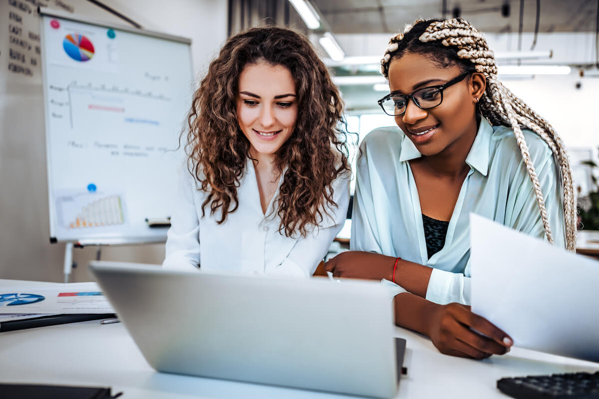 Position management: co-workers looking at a laptop