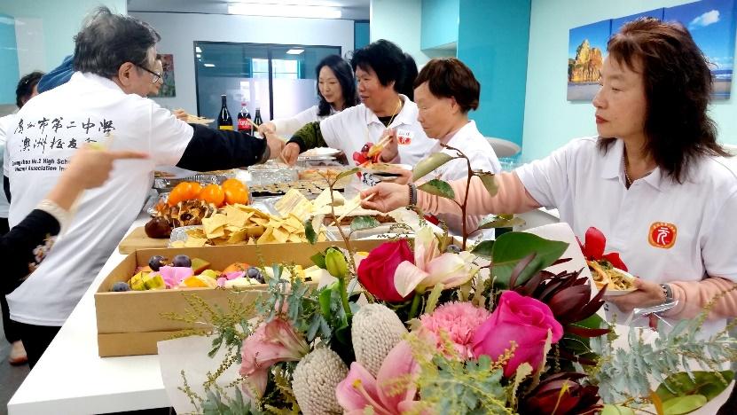 A group of people in a room with food

Description automatically generated with low confidence