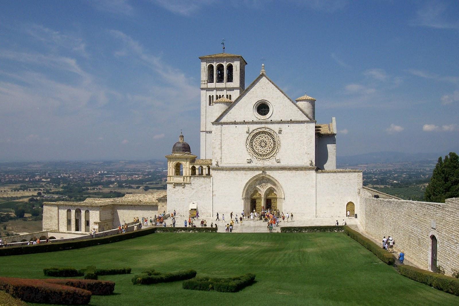 A photo of the Italian cathedral and monastery, Basilica of St. Francis of Assisi, along with a vast backdrop of the Italian city of Assisi.