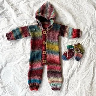 colorful baby romper and socks lying on a white fabric