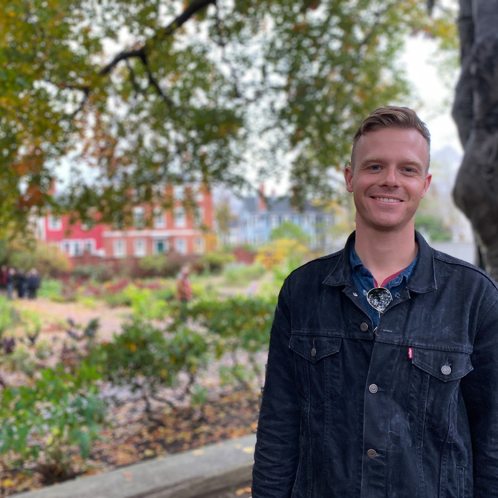 Young man dressed in jeans shirt posing in the garden