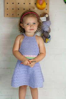 little girl wearing a purple crocheted dress
