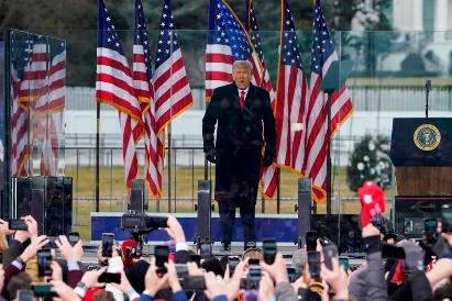 A person standing on a podium with a crowd of people around him

Description automatically generated with low confidence